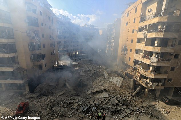 Rescuers survey the destruction at the site of an overnight Israeli airstrike in the southern Beirut suburb of Shayyah.