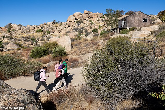 The researchers noted that adolescents, in particular, may be prone to psychosis due to greater exposure to traumatic events and the loss of friends and other social networks (pictured: Colombian asylum seekers walk through the desert after crossing the United States-Mexico border near Jacumba Hot Springs, California)