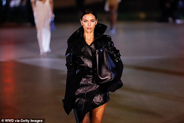 The supermodel, 38, strutted down the catwalk in a crocodile skin trench coat with a dramatic collar as she joined the star-studded show.