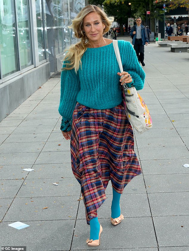 The star embraced the early fall look in a turquoise knit sweater and a plaid skirt that fell to her ankles.