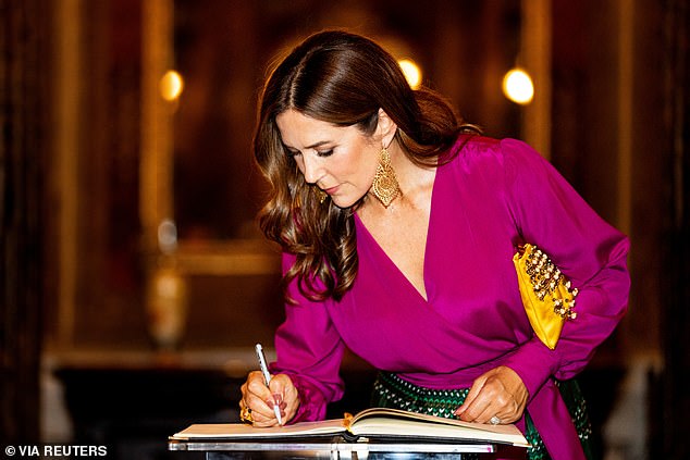 Queen Mary of Denmark writes in a guest book at the Teatro Amazonas in Manaus during her visit