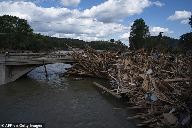 The National Hurricane Center predicts the storm will develop over the northwestern Caribbean Sea and southern Gulf of Mexico. Pictured: A group of broken pieces of wood from destroyed homes rest along a damaged bridge in Lake Lure, North Carolina.