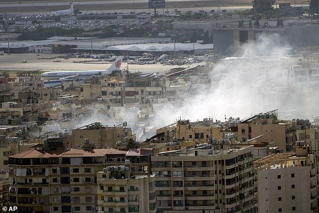 A plane prepares to take off from Rafik Hariri International Airport as smoke rises from the site of an Israeli airstrike in Dahiyeh, Beirut, Lebanon, Tuesday, October 1, 2024.