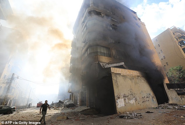 Firefighters work as clouds of smoke rise at the site of an overnight Israeli airstrike in the southern Beirut suburb of Hadath on October 2, 2024.