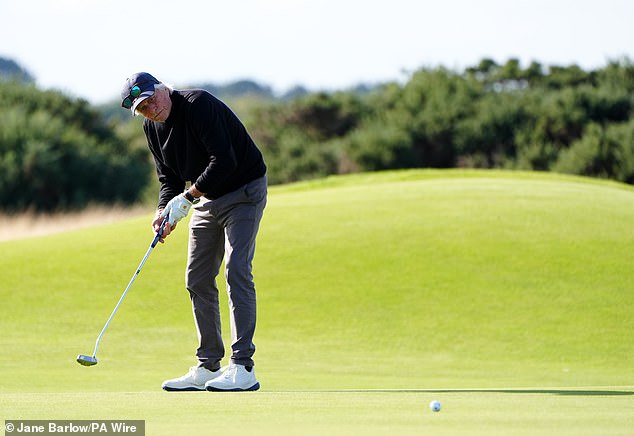 He cut a smart figure in a black jumper and gray trousers as the rain eased as he played on the famous Scottish pitch.