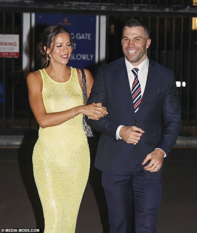 The skin-tight number stood out against the darker tones of her husband's outfit, and she paired the look with white strappy heels and a black bag.