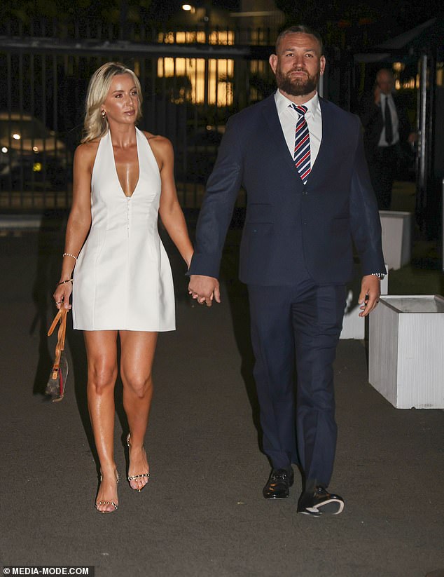 Jared Waerea-Hargreaves' wife Chelsea opted for a white halter-neck dress with a plunging neckline that flaunted her stunning assets. She accessorized it with a Louis Vuitton clutch and heels with rhinestones on the straps. Both in the photo