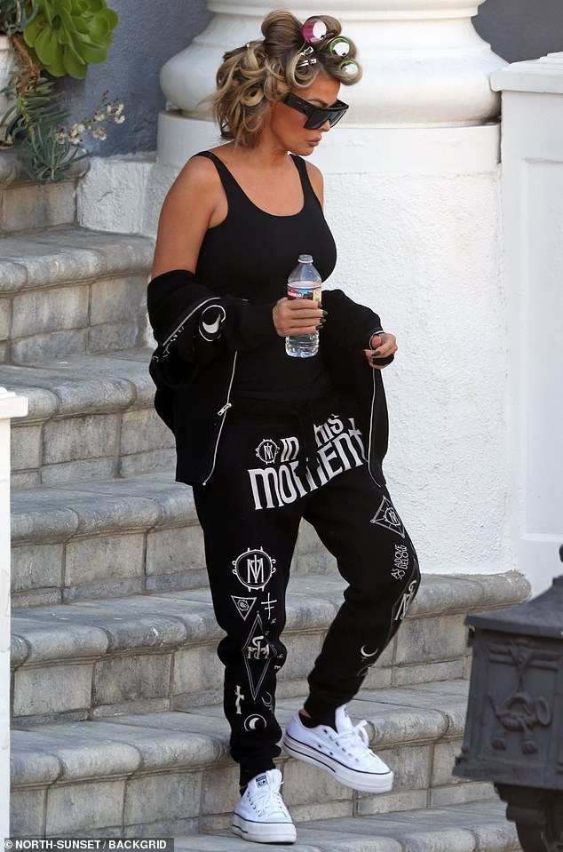 She opted for a casual ensemble of a black tank top with a sweatshirt and hoodie, wearing makeup but leaving the curlers in her hair.