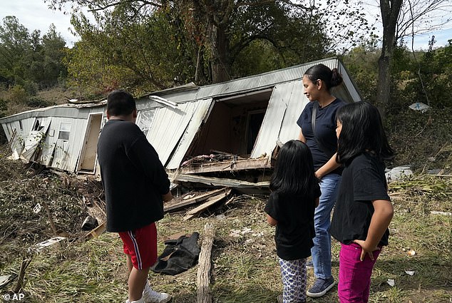 Marisol Juárez and her children stand in front of her family's destroyed mobile home, Tuesday, Oct. 1, 2024, in Hendersonville.