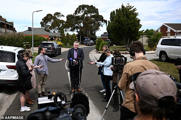 Journalists gathered at the crime scene where Inspector Thomas addressed them.