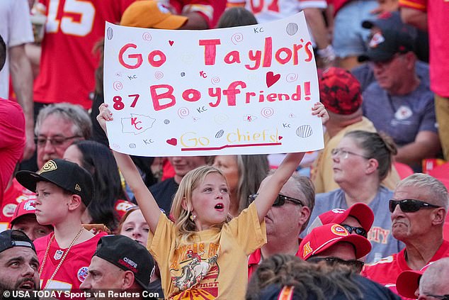 A young NFL fan holds a sign that says: 