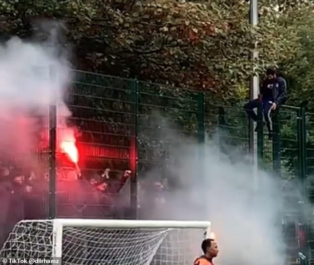 Another man was seen sitting on top of a high fence as the locals continued their game.