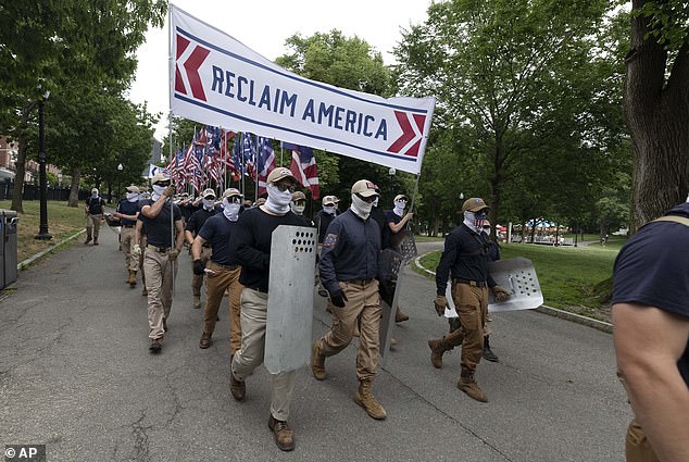 The protesters were all white and dressed identically, wearing white gaiters that covered most of their faces. They walked with a banner that said: 