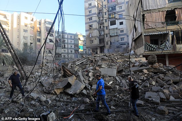 Residents check out the destruction following an Israeli attack in the Mreijeh neighborhood in Beirut's southern suburbs on October 4.