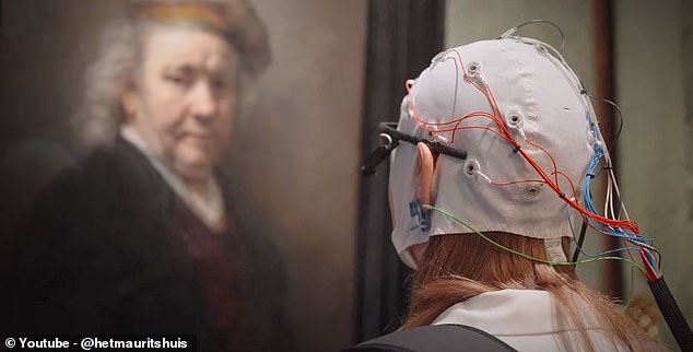 Scientists found that people's emotional responses were 10 times more powerful when looking at real art compared to posters. Pictured: A study participant examines art at the Mauritshuis Museum where 'Girl with a Pearl Earring' is on display