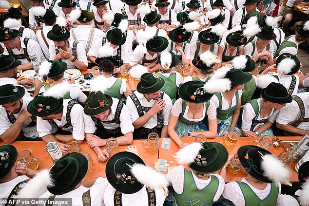 People dressed in traditional Bavarian clothing sit in a beer tent during the Oktoberfest on September 22.