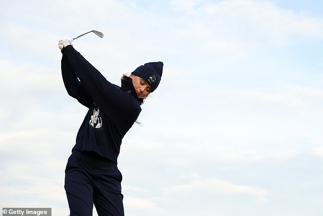 Dressed in a Ralph Lauren Polo sweater with a bear print on the front and a matching blue pom beanie, Kathryn celebrated taking her game seriously while swinging her stick.