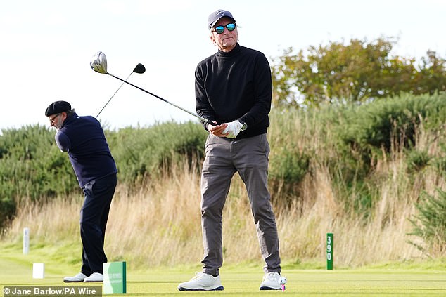 Wearing a pair of dark gray chinos, a black turtleneck and a navy blue cap, he looked after taking his swing seemingly dissatisfied.