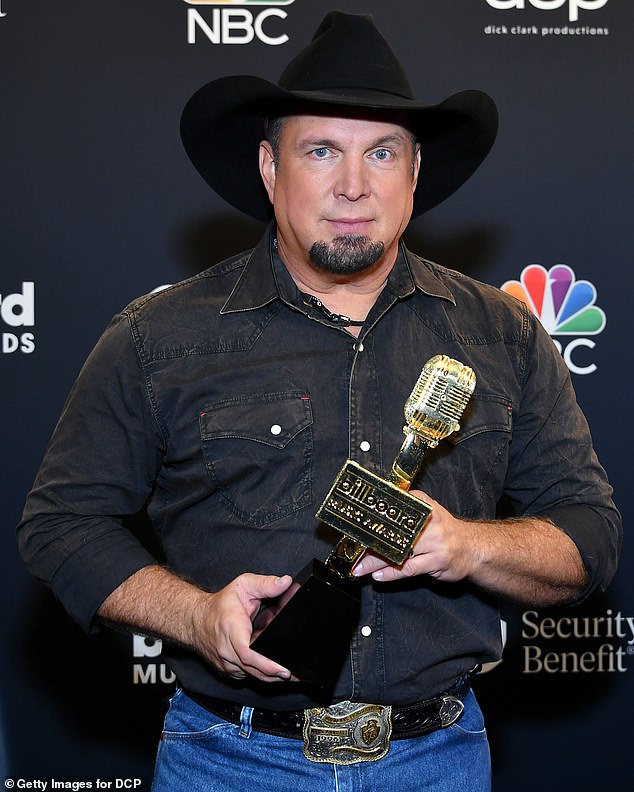 Brooks is pictured at the 2020 Billboard Music Awards, holding an Icon Award