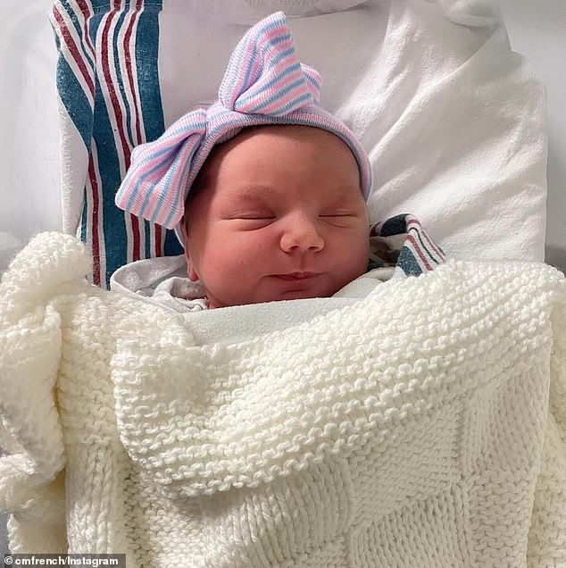 The newborn modeled her hat with a bow tie on her head.