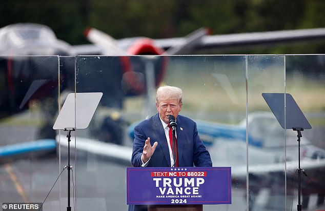 Republican presidential candidate and former United States President Donald Trump speaks behind bulletproof glass during a campaign rally, at the North Carolina Aviation Hall of Fame and Museum in Asheboro, North Carolina North, USA, August 21, 2024.