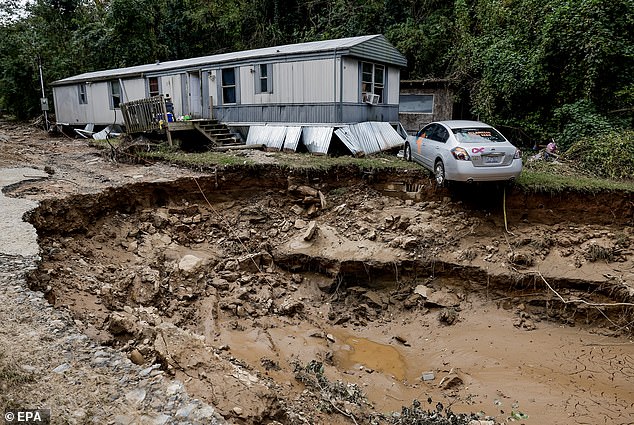 A mobile home and car along the Swannanoa River after catastrophic flooding caused by Tropical Storm Helene in Swannanoa, North Carolina, on October 3.