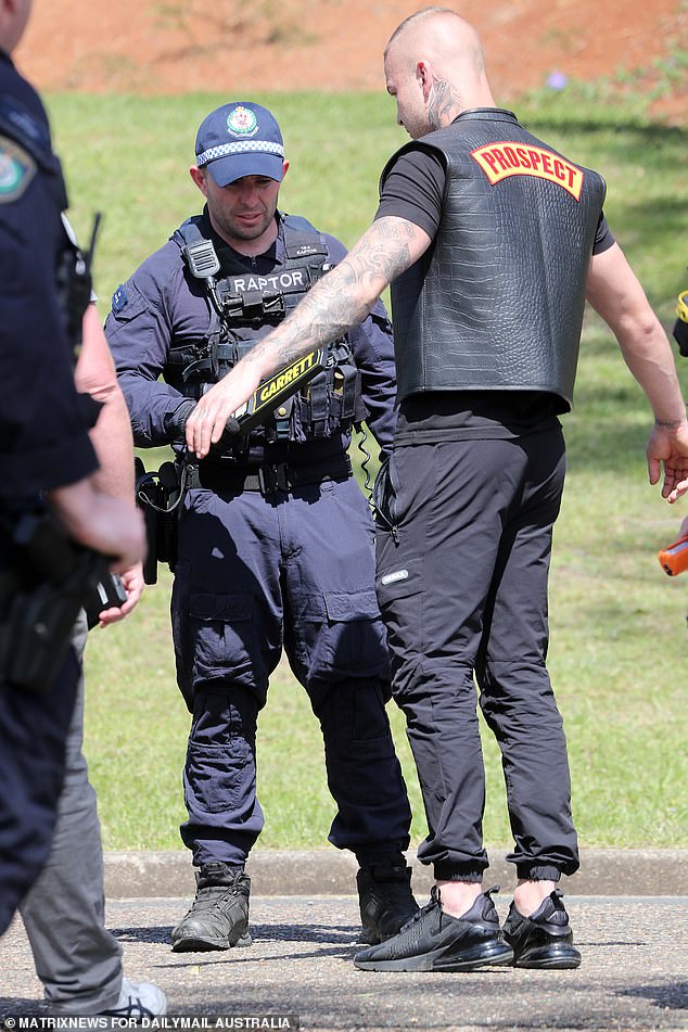 A man is seen being scanned by a metal detector outside the funeral.