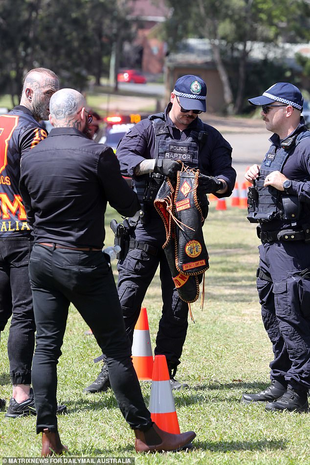 A police officer is seen checking the Bandidos colors.