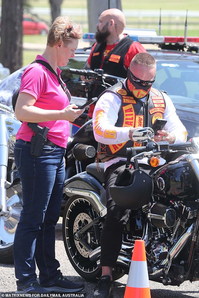 A woman is seen checking a man's license as he arrives at the event.