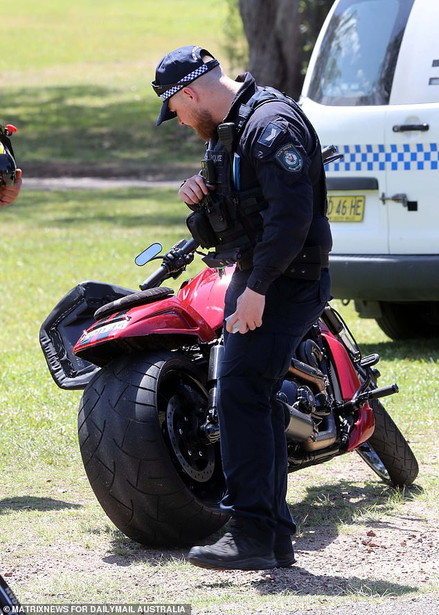 An officer is seen inspecting a motorcycle parked outside the Port Macquarie funeral.