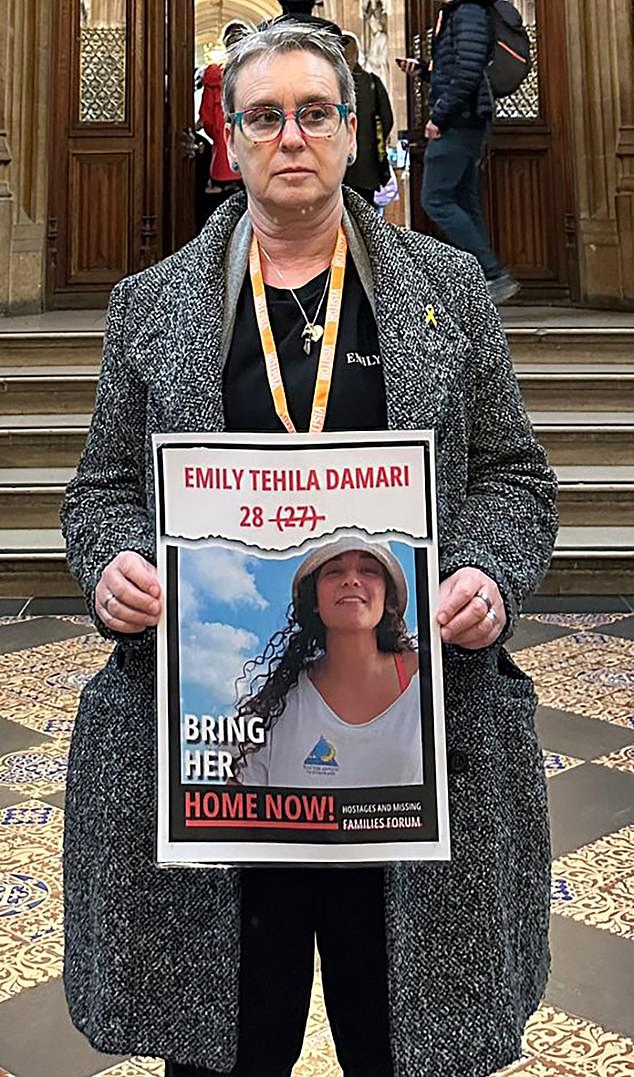 Mandy Damari is pictured holding a poster of her daughter Emily. He asks for his daughter's return