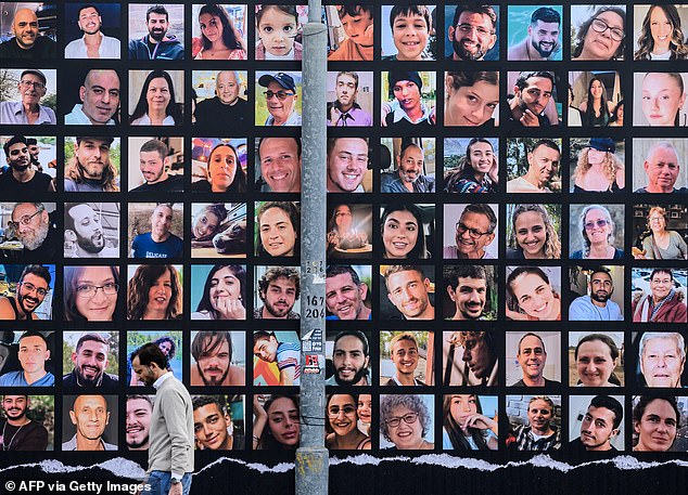 Monday will mark one year since the largest massacre of Jews since the Holocaust, the October 7 attacks in which 1,200 people were murdered in cold blood by Hamas terrorists. Pictured: A man walks past a giant poster with portraits of Israeli hostages held in Gaza since the October 7 attack.