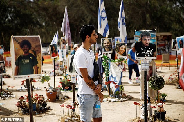 Shye Klein, 27, a photographer and Nova festival survivor, looks at a portrait of Dor Avitan, whom he met while attending the festival before the deadly Hamas attack on October 7, at the Nova festival site in Reim, south of Israel.