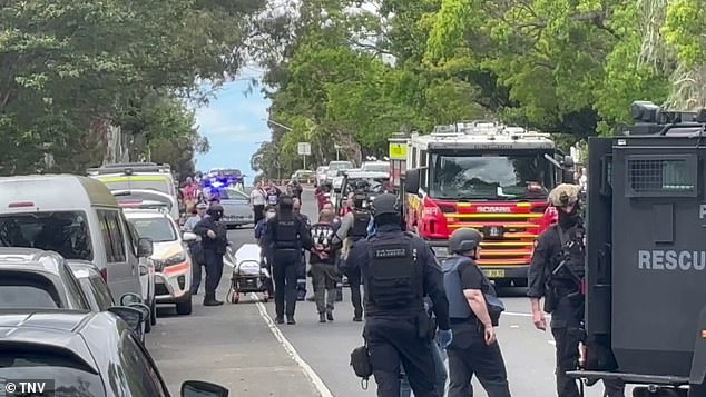 The man is seen being led away by police in handcuffs after the incident.