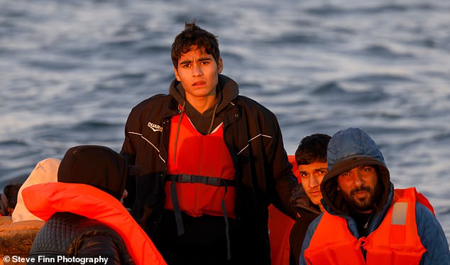 Pictured: Three of the men on the boat carrying a family of 16 Iranian immigrants, including two pregnant women.