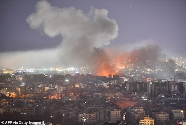 Smoke rises amid flames after an airstrike targeted a neighborhood in the southern suburb of Beirut.