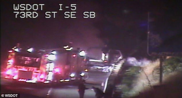 As firefighters spent the final seconds of the footage completely extinguishing the fire, the man can be seen speaking to a police officer before backing away and attempting to sit back down on the barrier; He was arrested at the scene on suspicion of driving while intoxicated.