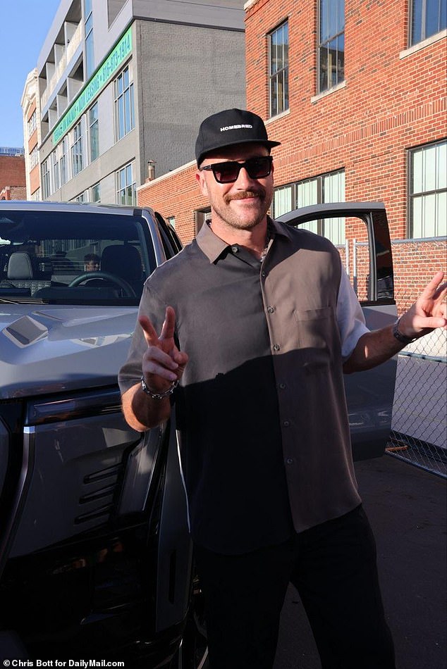 Kelce arrived in style at his charity event and posed with one of the cars on display