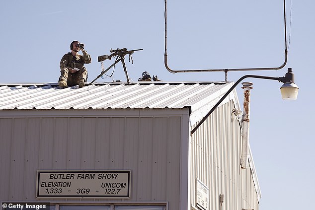 A police sniper positions himself on a rooftop before a rally by Republican presidential candidate, former United States President Donald Trump, at Butler Farm Show Inc. on October 5, 2024 in Butler, Pennsylvania.