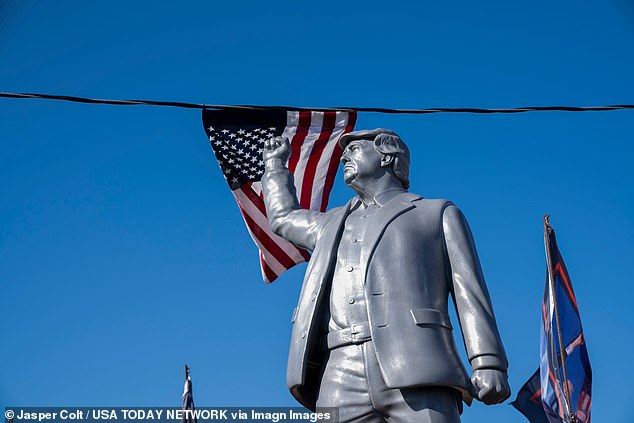 A statue of former President Donald Trump with his fist raised waves to supporters before Trump speaks at a campaign rally in Butler, Pennsylvania, on October 5, 2024.