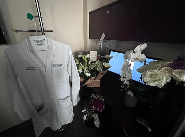 West's empty corner desk is adorned with floral tributes and his hospital jacket.