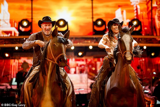 Former footballer Paul Merson and Karen Hauer simulate horseback riding during their performance