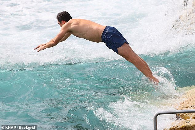 Peter showed off his fitness in a pair of navy shorts and had fun splashing in the waves.