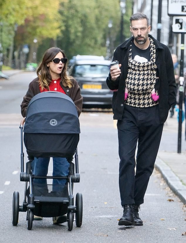 Meanwhile, Jamie, 35, cradled the couple's little one to her chest in a baby carrier, with the newborn's feet poking out, dressed in bright pink socks.