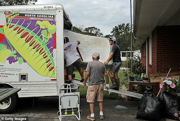 A North Carolina resident rescues what's left of his belongings from his flooded home in Kinston after Hurricane Florence in 2018.