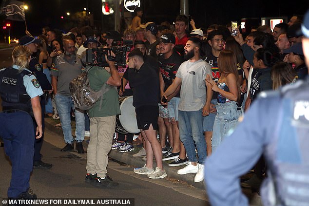 Two police officers are pictured watching the celebrations in Penrith.