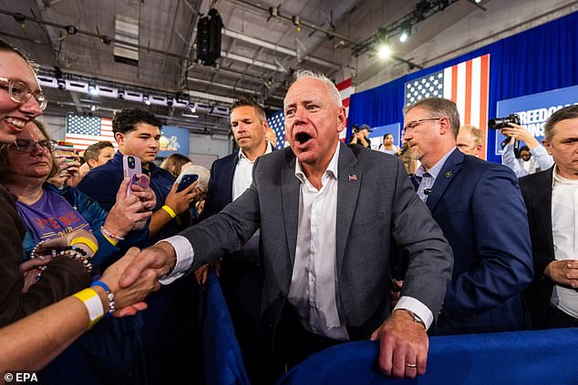 Minnesota Governor and Democratic vice presidential candidate Tim Walz (C) greets supporters at a campaign rally.