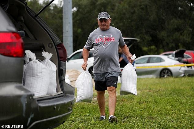 Rene Guerra carries sandbags as they are distributed to Pinellas County residents ahead of the expected arrival of Tropical Storm Milton, in Seminole, Florida, on Sunday.