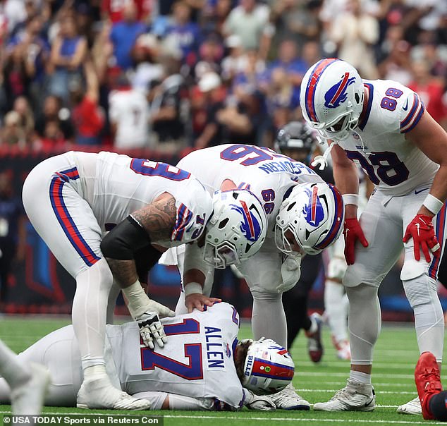 Concerned teammates stood over the quarterback after his head bounced off the grass.