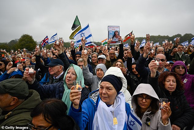 Crowds hold candles and banners during a minute's silence showing photographs of Israeli hostages as Jewish groups in the UK mark the first anniversary of October 7.